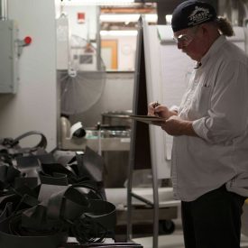 American sculptor Albert Paley writes on notebook in art workshop