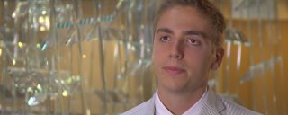 Closeup of Matthew, a Corning intern, glass sculpture in background