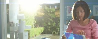 Sun shines into bedroom of girl using transparent electronic device 