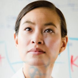 Montage: woman's face, writing on glass board in foreground